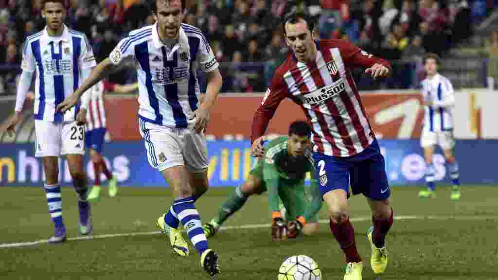 Real Sociedad's defender Mikel Gonzalez (L) vies with Atletico Madrid's Uruguayan defender Diego Godin during the Spanish league football match Club Atletico de Madrid vs Real Sociedad de Futbol at the Vicente Calderon stadium in Madrid on March 1, 2016. / AFP / GERARD JULIEN        (Photo credit should read GERARD JULIEN/AFP/Getty Images)
